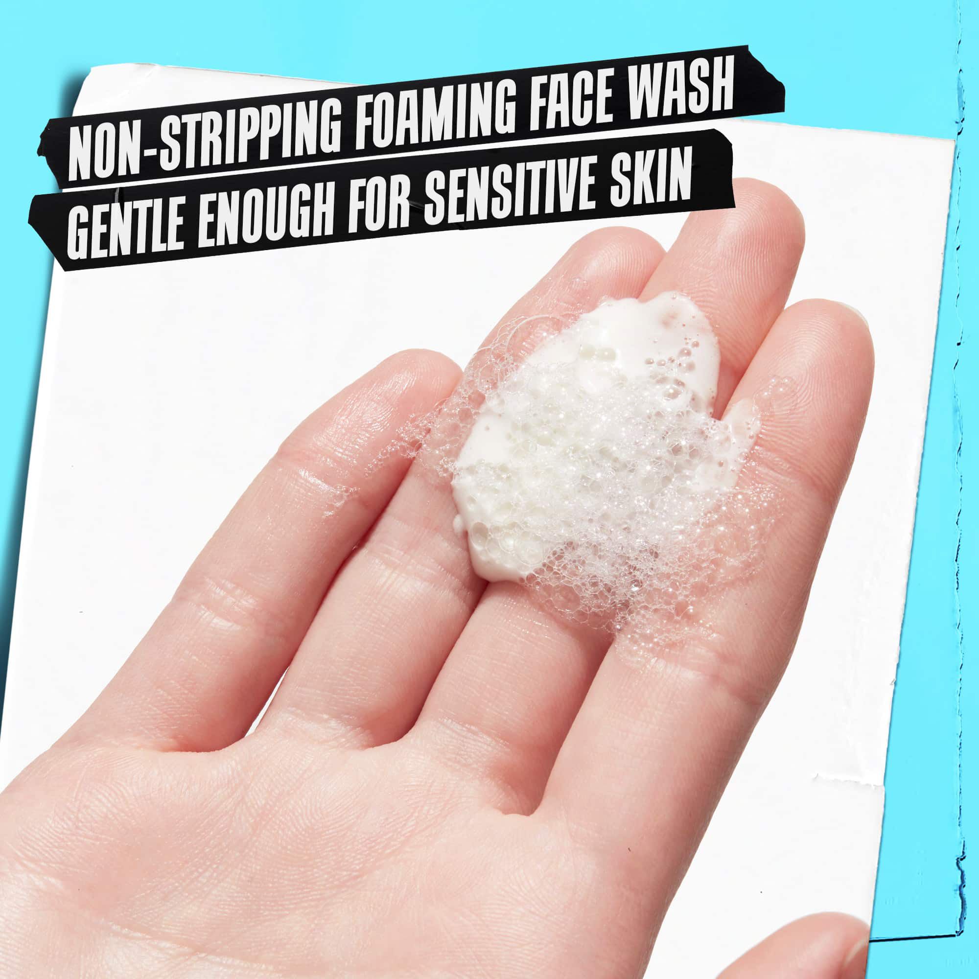 Una mano sosteniendo la espuma de Ultra Facial Oil-Free Cleanser con la etiqueta "Limpiador espumoso no agresivo, lo suficientemente suave para pieles sensibles."