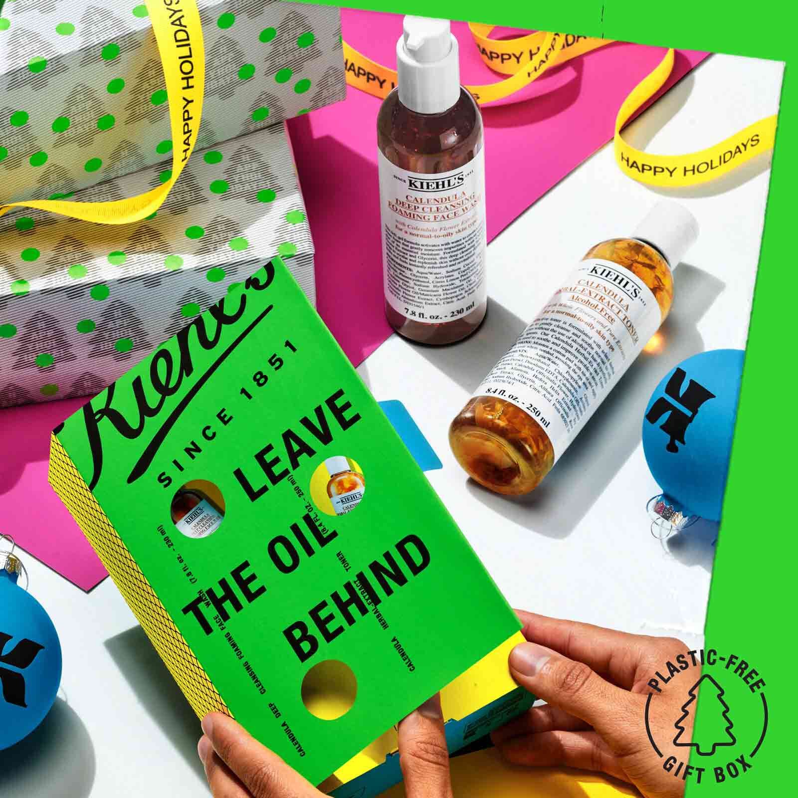 Hands opening Leave the Oil Behind gift set with a festive background