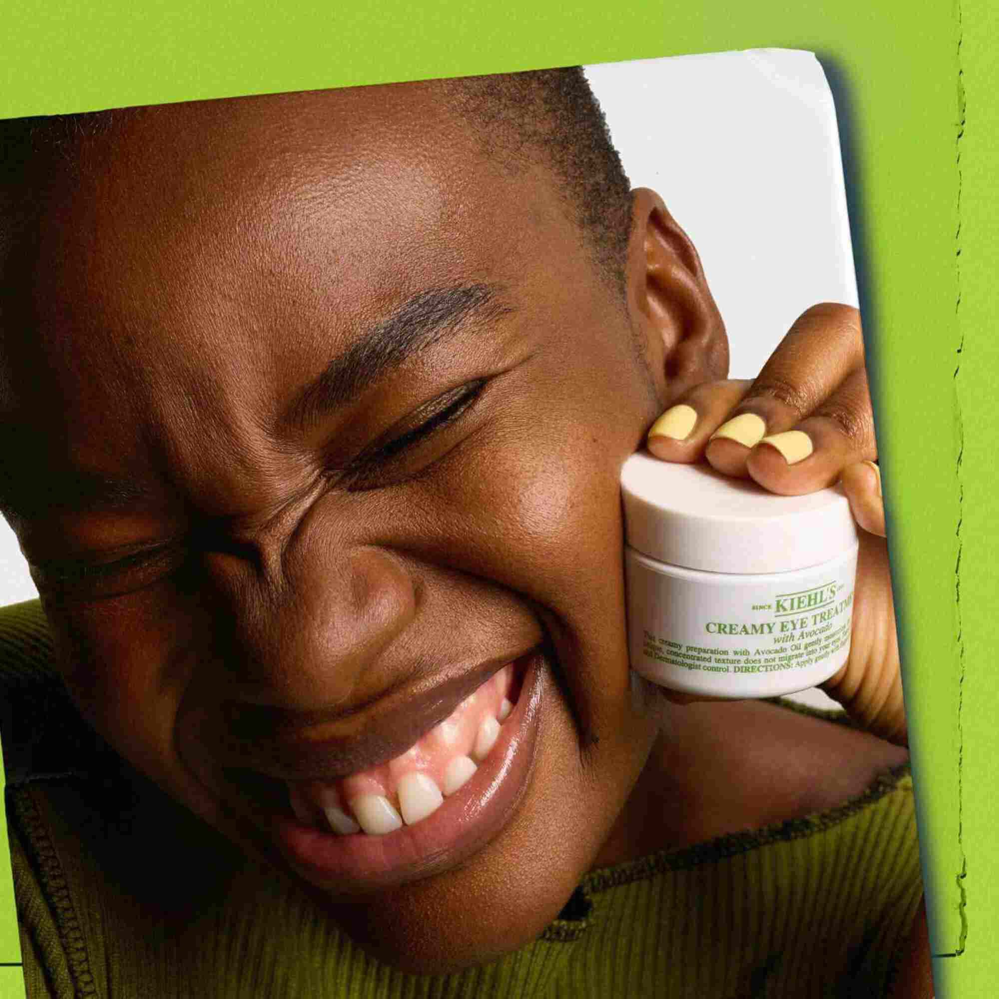 Modelo sosteniendo un tarro de Kiehl's Creamy Eye Treatment with Avocado