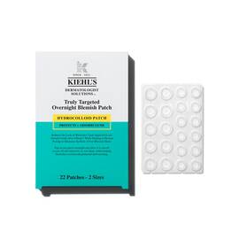  Kiehl’s Truly Targeted Overnight Blemish Patch box beside a clear sheet of circular hydrocolloid acne patches in assorted sizes.