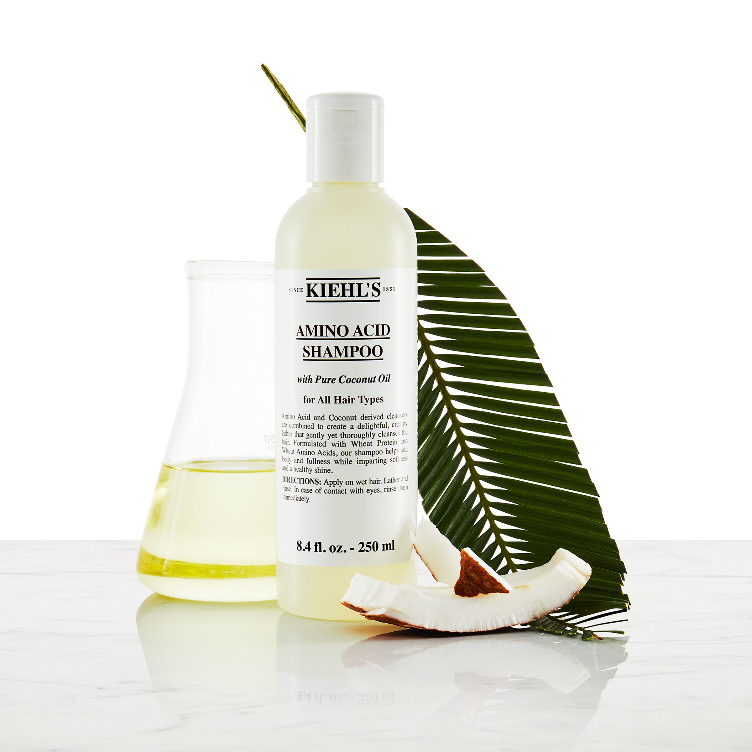 Modelo con bigote y un frasco de champu Amino Acid Shampoo de Kiehl's