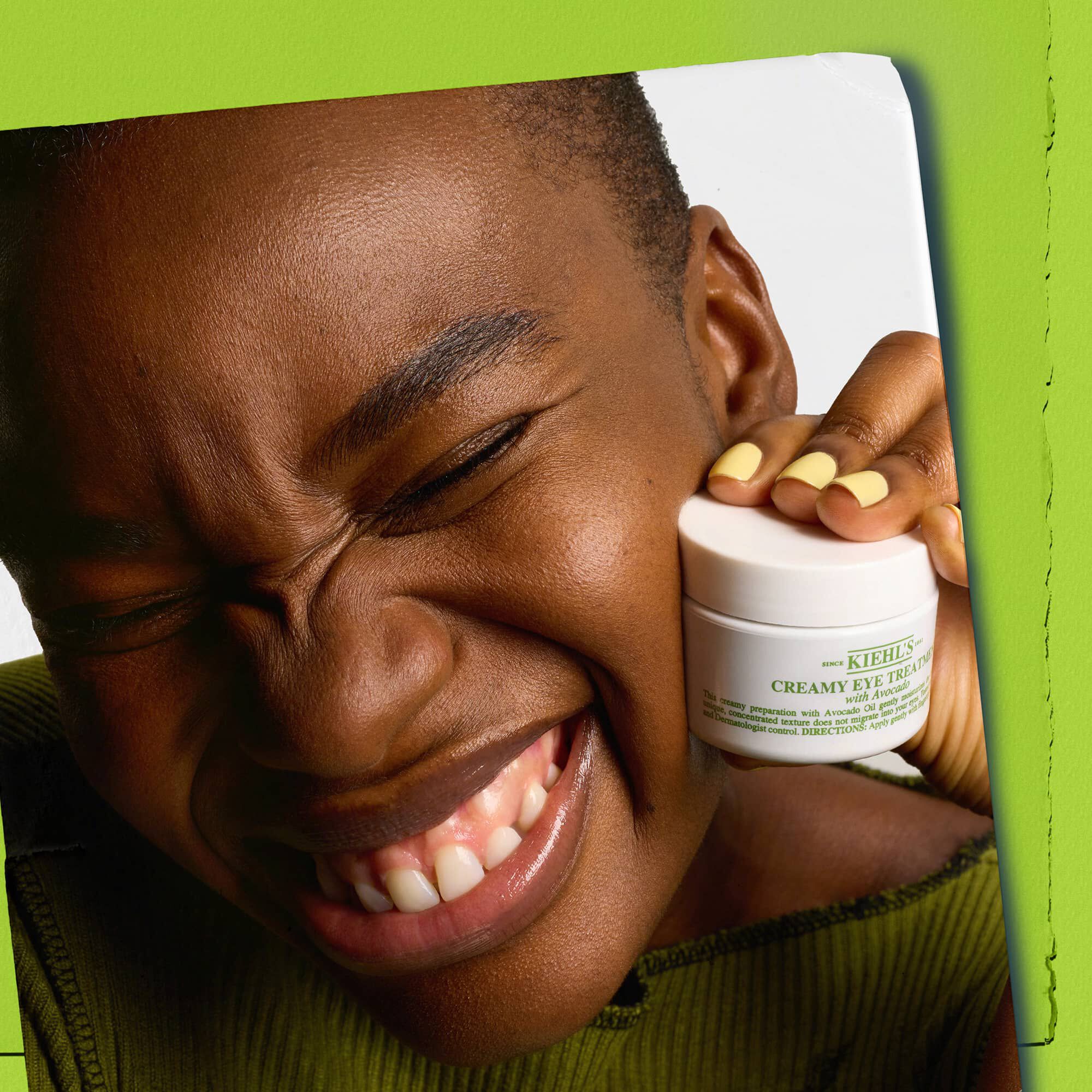 Modelo sosteniendo un tarro de Kiehl's Creamy Eye Treatment with Avocado