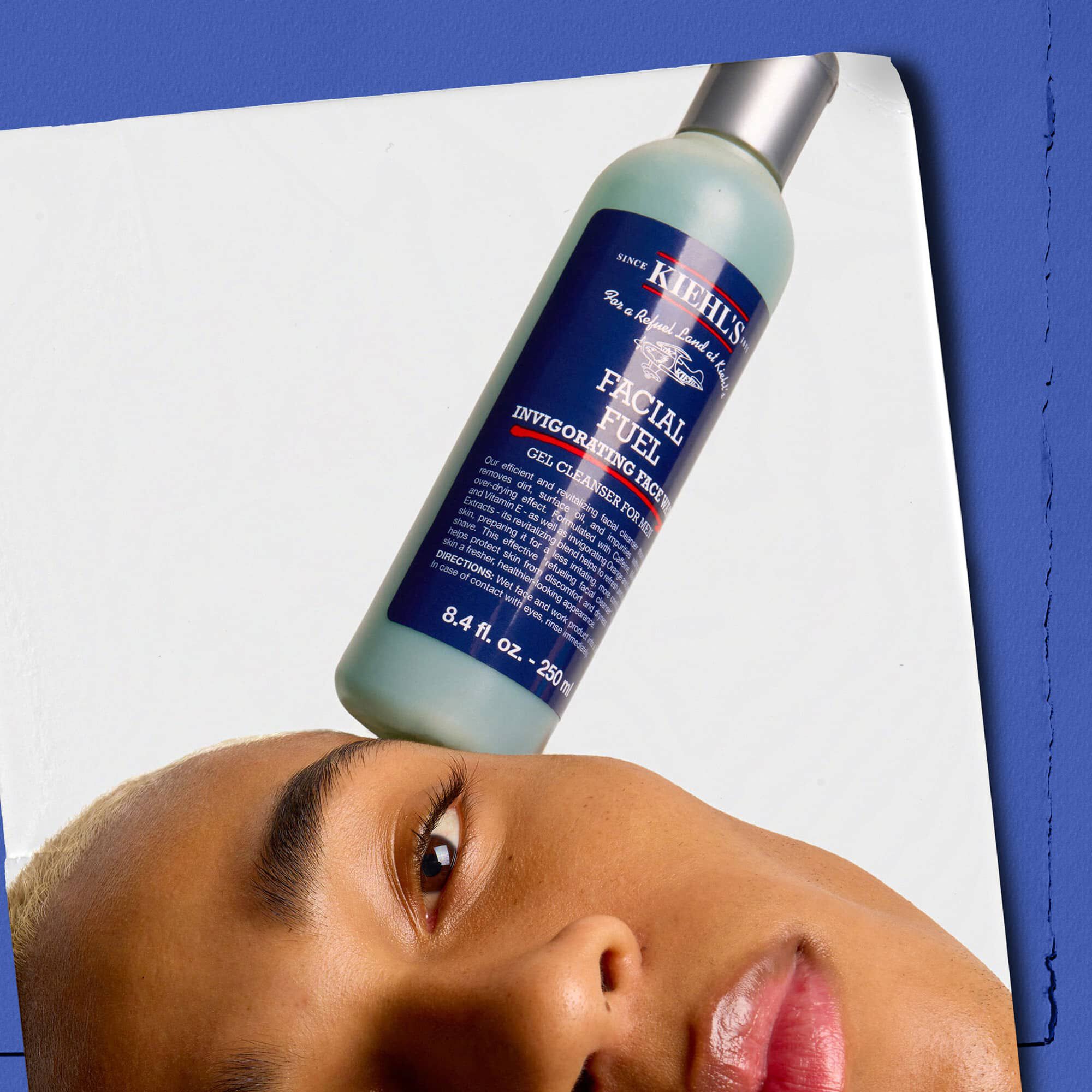 Modelo con un frasco de Kiehl's Facial Fuel Energizing Face Wash en equilibrio sobre su rostro