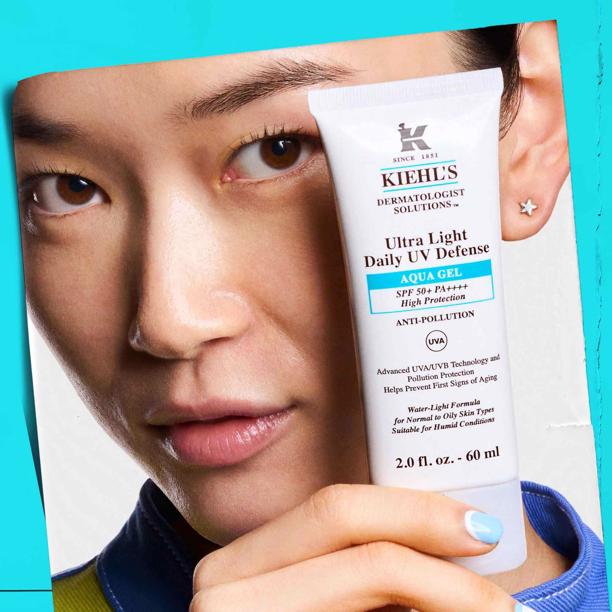 Una modelo sosteniendo un tubo de Ultra Light Daily UV Defense Aqua Gel, mostrando su portabilidad y facilidad de uso.