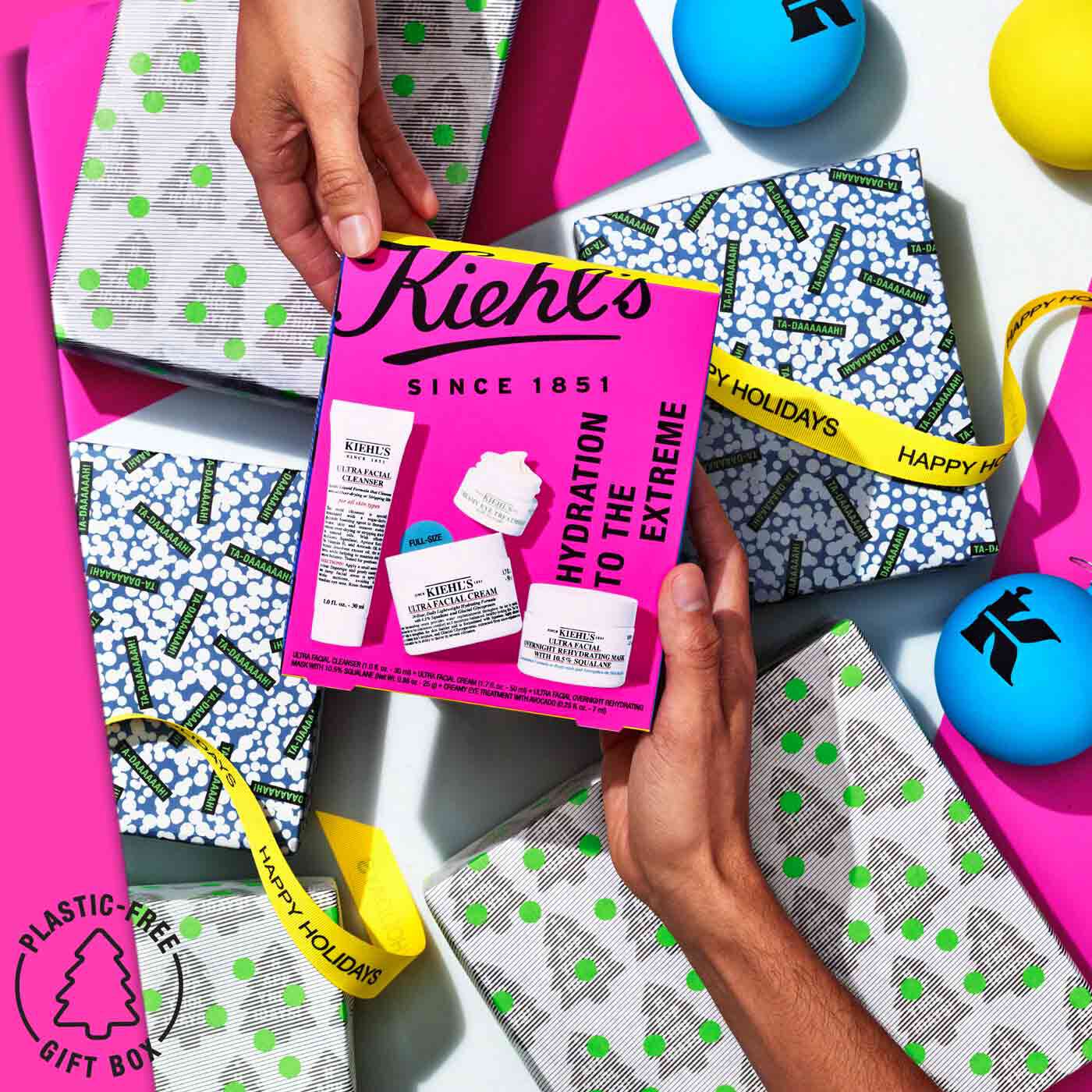 Hands exchanging the Hydration to the Extreme gift set above wrapped gifts and decorations