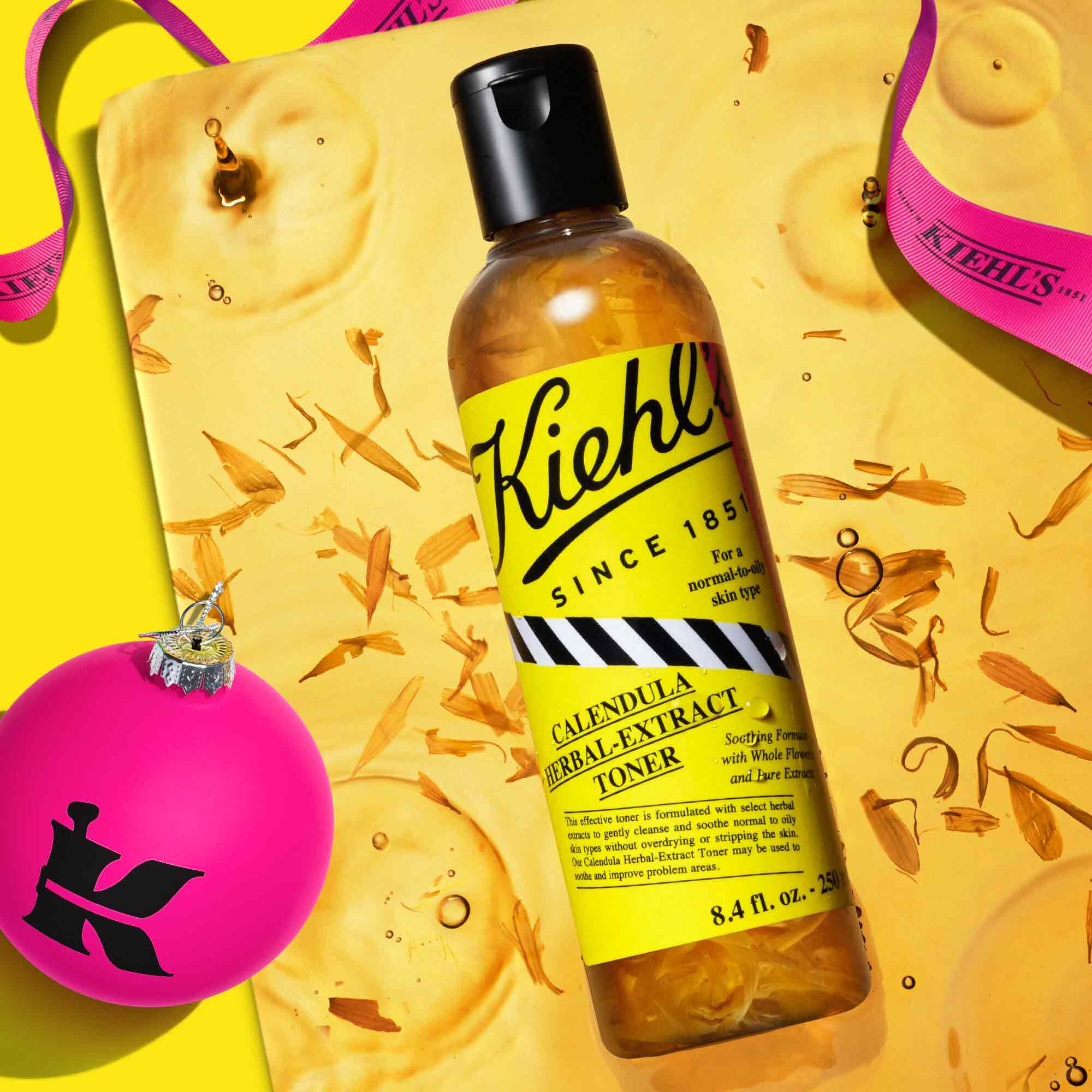 Calendula Herbal-Extract Toner bottle on top of an ingredient closeup with K branded ornament 