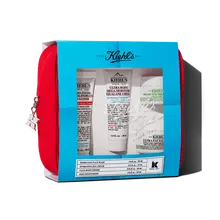 Kiehl's travel-sized skincare gift set in a red pouch, featuring multiple products visible through a blue-themed window.