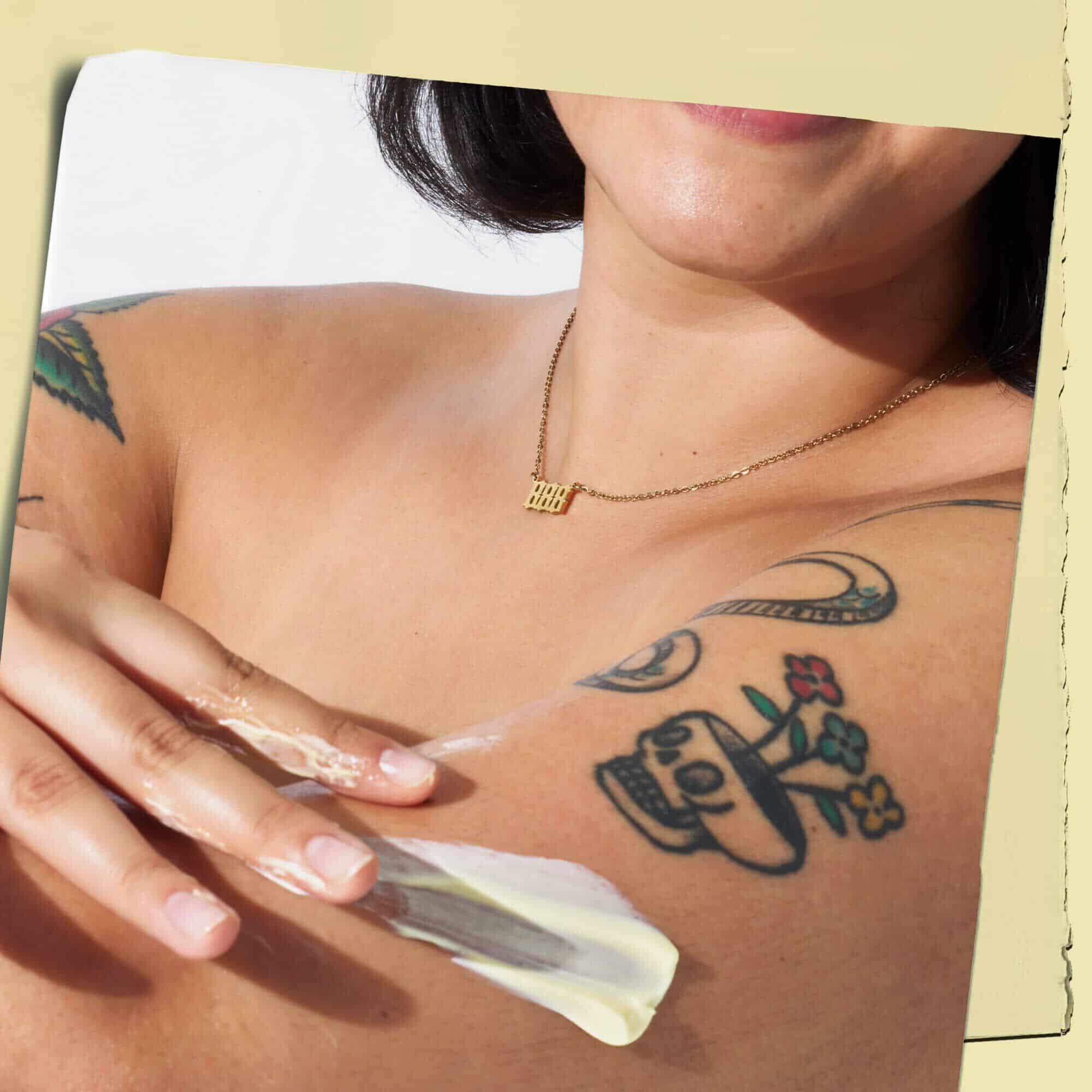 Modelo tatuado con la textura de la locion corporal Kiehl's Creme de Corps en su piel