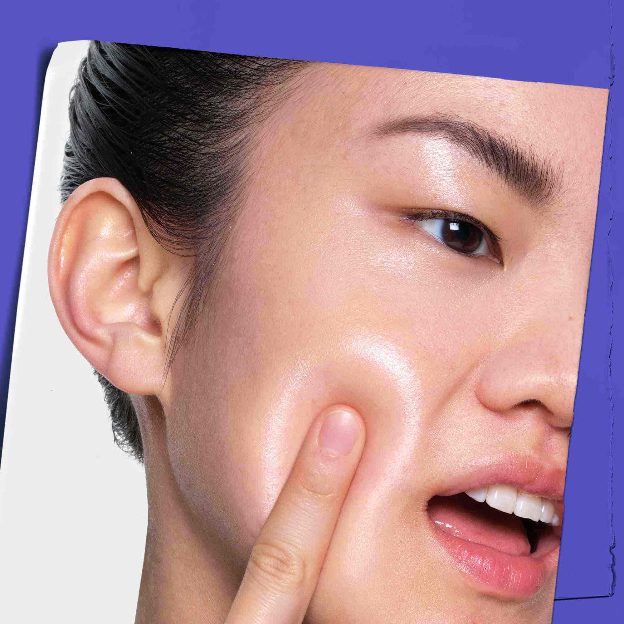 Una persona aplicando Clearly Corrective Dark Spot Solution en su piel.