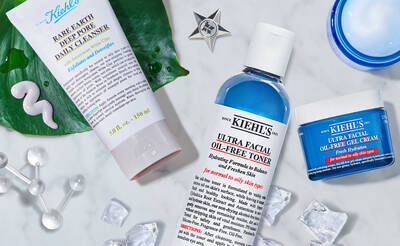 A flat lay of skincare products including Kiehl's Ultra Facial Oil-Free Toner, a daily cleanser labeled "Rare Earth Deep Pore Daily Cleanser," and a blue gel cream, all arranged with decorative elements like ice cubes and a star-shaped ornament.