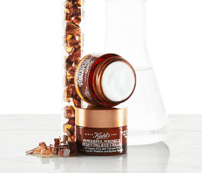 Crema para ojos antiarrugas de Kiehl's con ingredientes rejuvenecedores, presentada junto a cristales y un frasco de vidrio.