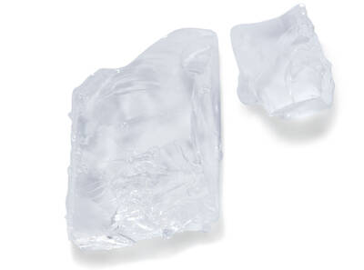 Dos trozos de hielo transparente sobre fondo blanco, uno grande y otro pequeno, brillando con luz natural.