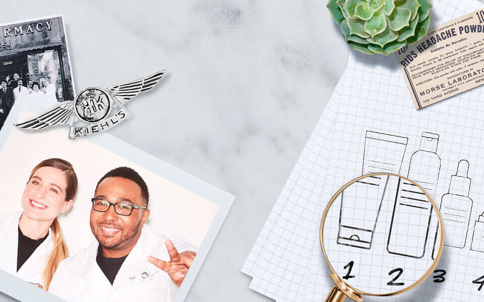 Dos personas sonrientes, un hombre y una mujer, visten batas de laboratorio frente a una mesa con productos de belleza y un esquema de envases en un cuaderno.