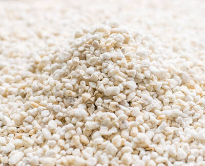 A close-up of a small mound of white, granular material resembling small pebbles or grains.