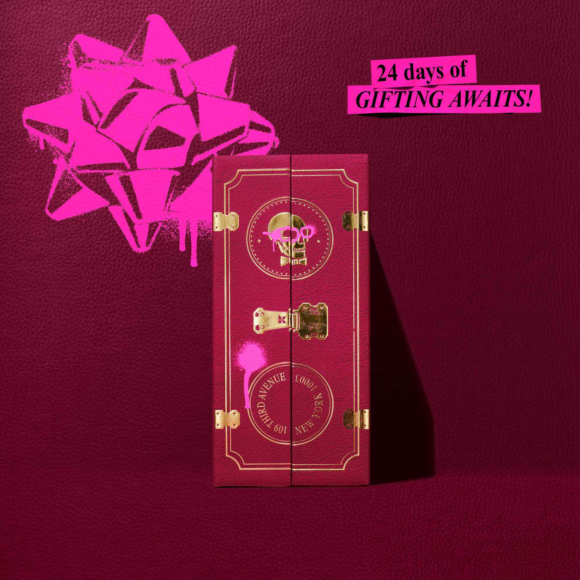Una caja burdeos oscuro del calendario de Adviento de Kiehl's aparece cerrada sobre un fondo texturizado a juego. El texto en lamina dorada de la caja reza “COMPARTIENDO ALEGRIA DESDE 1851" con “CALENDARIO DE ADVIENTO" en la parte inferior. Sobre la caja hay un lazo rosa brillante de estilo graffiti y, en la esquina superior derecha, una pancarta rosa que dice: “¡24 dias de REGALOS TE ESPERAN!"
