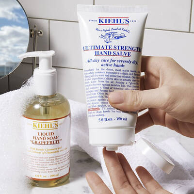 Dos productos de cuidado de manos de Kiehl's: jabon liquido de uva y crema para manos intensiva sobre un fondo blanco.