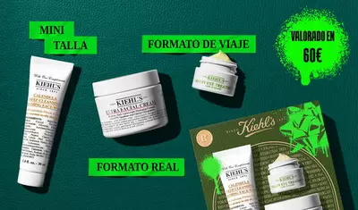 A Kiehl’s gift set is shown with three products placed in front of a green, gold, and neon green decorated box. The products include Calendula Deep Cleansing Foaming Face Wash, Creamy Eye Treatment with Avocado, and Ultra Facial Cream. The packaging features the Kiehl’s logo and festive holiday designs.