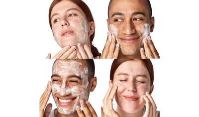 Dos personas aplicando un limpiador facial, disfrutando del momento con sonrisas y expresiones de satisfaccion.