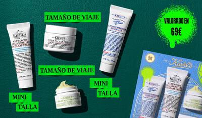 A graphic, set against a dark green textured background, features four Kiehl’s products and a gift box. A white tube of "KIEHL’S ULTRA BODY MEGA MOISTURE SQUALANE CREAM" is labeled "DELUXE SAMPLE" in bright green. A white jar of "KIEHL’S ULTRA FACIAL CREAM" is labeled "TRAVEL SIZE" in bright green. A white tube of "KIEHL’S ULTIMATE STRENGTH HAND SALVE" is labeled "DELUXE SAMPLE" in bright green. A small open white jar of "KIEHL’S CREAMY EYE TREATMENT WITH AVOCADO" with visible pale yellow cream is labeled "TRAVEL SIZE" in bright green. In the lower right, a blue Kiehl’s gift box showcasing the same four products is visible, decorated with bright green graphic paint splatters and a bow design