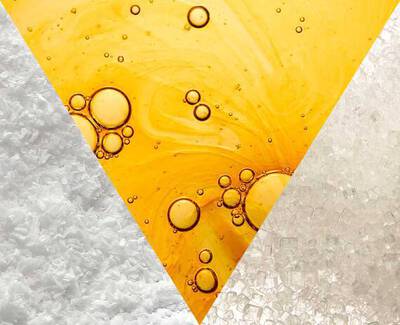 Textura de sal blanca, aceite amarillo y sal cristalina dispuestas en un diseno triangular.