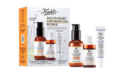 Conjunto de productos de cuidado de la piel de Kiehl's, que incluye sueros y cremas para reducir lineas y arrugas, presentado en una caja blanca y naranja.
